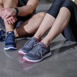 Couple sitting on the floor wearing gray DW sneakers for wide and diabetic feet.