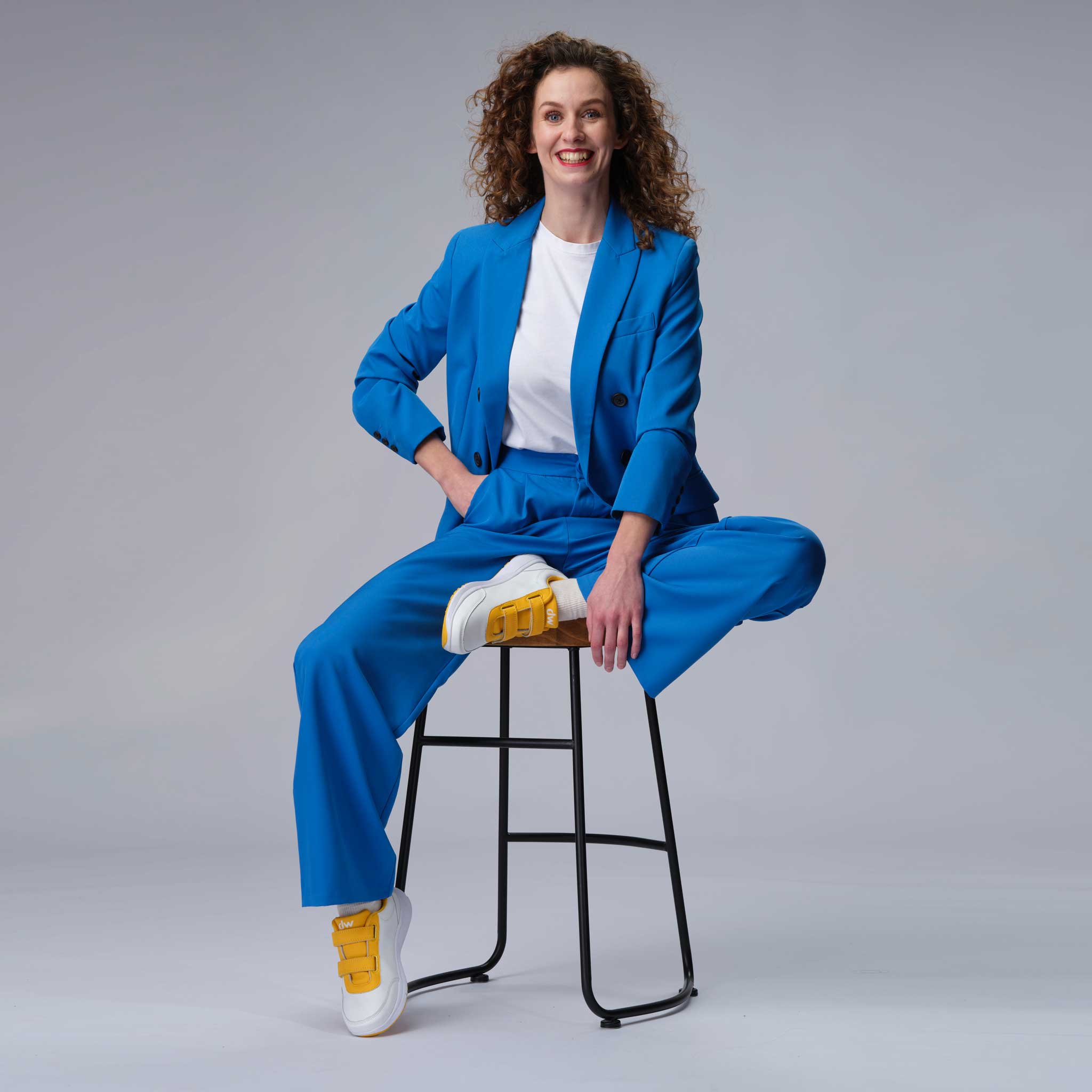 Woman sitting in yellow Diawin shoes designed for wide diabetic feet.